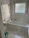 Tageslichtbad mit weißen Santitärobjekten und weiße Wand- un Bodenfliesen.jpg - 3 Zimmer Etagenwohnung in Bad Vilbel
