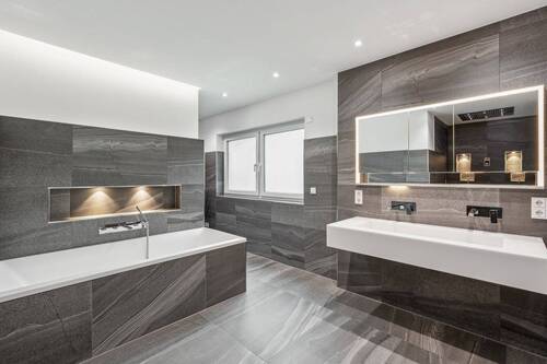 Das Masterbad im ersten Obergeschoss präsentiert sich mit allen Annehmlichkeiten wie der geräumigen Regenwalddusche - 