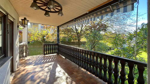 Überdachter Balkon mit Blick in den großen Garten - 