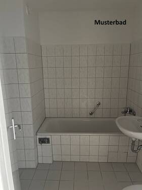 Musterbad mit Badewanne, weißen Sanitärobjekten, hellen Wand- und Bodenfliesen und Waschmaschinenanschluss - 