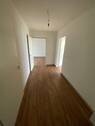 Blick Eingang in die Diele mit braunem PVC-Boden und weißen Wänden - 2 Zimmer Etagenwohnung zur Miete in Meerbusch