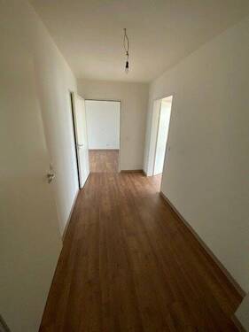Blick Eingang in die Diele mit braunem PVC-Boden und weißen Wänden - 2 Zimmer Etagenwohnung zur Miete in Meerbusch