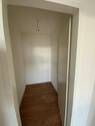 Blick Eingang in Abstellraum mit braunem PVC-Boden und weißen Wänden - 