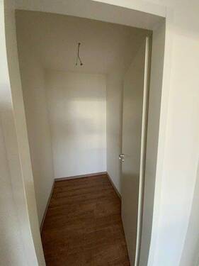 Blick Eingang in Abstellraum mit braunem PVC-Boden und weißen Wänden - 