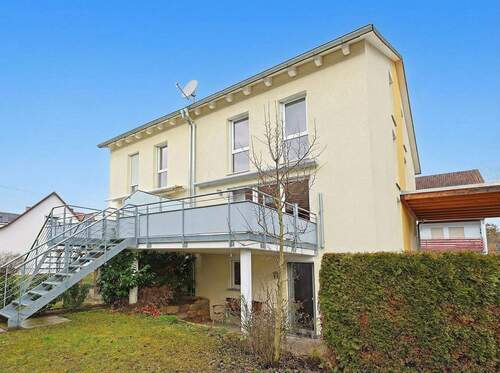 Hausansicht vom Garten mit überdachter Terrasse und großem Balkon - Moderne Doppelhaushälfte mit großem Balkon und überdachter Terrasse