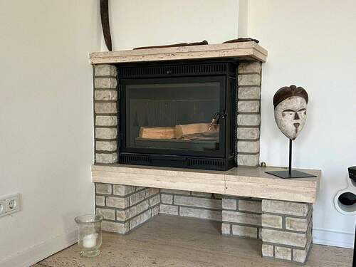 Der Kamin schafft eine warme, einladende Atmosphäre und bildet einen stilvollen Blickfang im Wohnbereich. - 