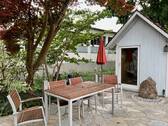 Sitzecke mit Quellstein und Gartenhütte - 