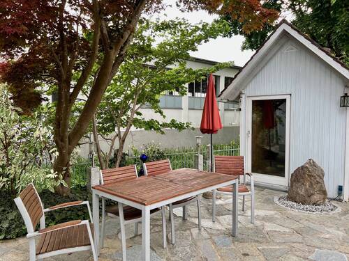Sitzecke mit Quellstein und Gartenhütte - 