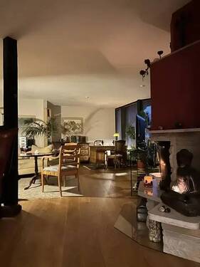 Wohnzimmer mit Kamin am Abend - Luxus-Dachgeschoss mit großer Terrasse in Süd-Westausrichtung und einem Winterkamin
