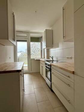 Küche mit Einbauküche und Zugang zum Balkon - 