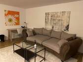 Wohnzimmer mit Couch und Tisch - 2 Zimmer Etagenwohnung in München