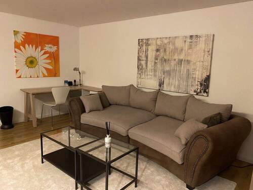 Wohnzimmer mit Couch und Tisch - 2 Zimmer Etagenwohnung in München