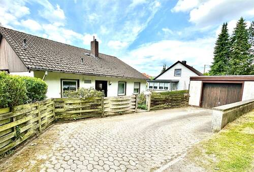 Fassade Vorne mit Garage und Stellplatz - 