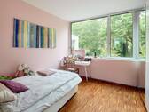 Blick in eines der Kinderzimmer, das sich nach Süden ins Grüne öffnet - 