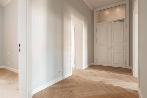 Blick vom Flur auf die Eingangstür. Links befindet sich das Schlafzimmer, links hinten das Badezimmer und rechts das Wohnzimmer. - 