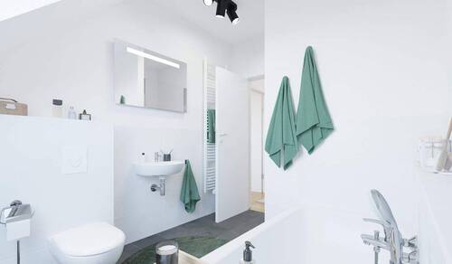 Ein modern gefliestes Badezimmer mit Badewanne und - 