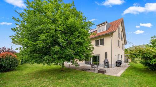 Außenbereich mit großer Grünfläche und breiter Terrasse - 