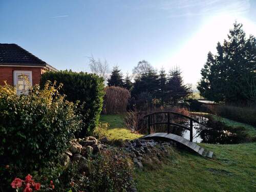 Malerische Landschaft und so ein liebevoll gepflegter Garten mit Brücke - 