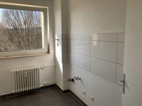 Küche mit Blick ins Grüne, weißem Fliesenspiegel und Bodenfliesen in anthrazit - 2 Zimmer Etagenwohnung zur Miete in Friedrichsdorf