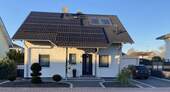 Ansicht von vorne + PV-Anlage - Modernes, freistehendes Einfamilienhaus in naturnaher Lage von Bürstadt - ideal für Familien