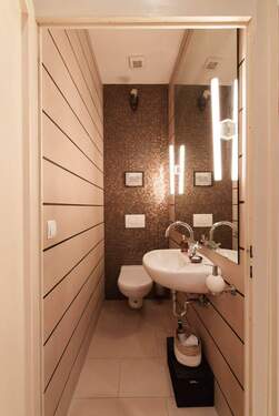 Exklusives Gäste-WC mit Design-Mosaikwand und cleverer Raumnutzung - 