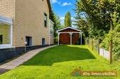 Seitlicher Gartenbereich mit Zugang zum Wintergarten und Nebengebäude - 