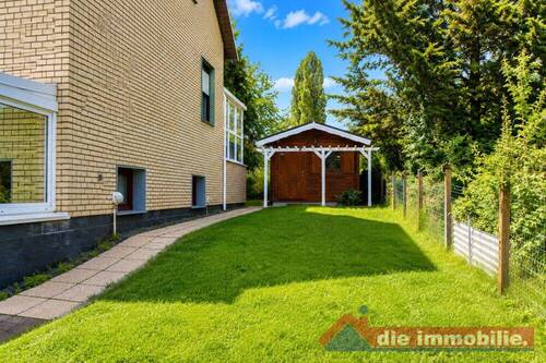 Seitlicher Gartenbereich mit Zugang zum Wintergarten und Nebengebäude - 
