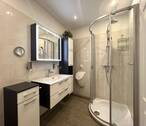 Blick auf Dusche, Waschtisch und Pissoir - 