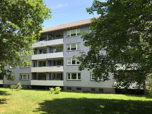 Birkenallee 49: Außenansicht über die Grünanlage mit altem Baumbestand auf die, nach Westen ausgerichteten, Balkone. - 3 Zimmer Etagenwohnung zur Miete in Baunatal