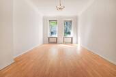 Wohnzimmer mit Altbauflair dank verzierten Stuckelementen - 3 Zimmer Etagenwohnung zum Kaufen in Berlin