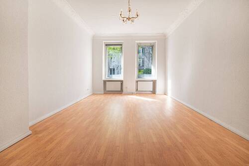 Wohnzimmer mit Altbauflair dank verzierten Stuckelementen - 3 Zimmer Etagenwohnung zum Kaufen in Berlin