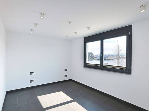 Freundliches Schlafzimmer mit großen Fenstern und schönem Ausblick - 
