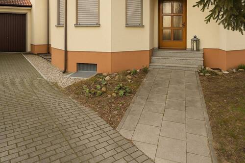 Komfortabler Hauseingang mit durchdachter Wegeführung und charmantem Naturstein-Akzent - Doppelhaushälfte mit Garage in ruhiger Lage von Delitzsch-Selben