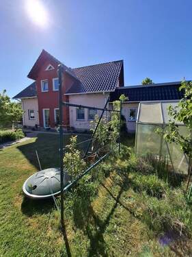 Gewächshaus und Regenwassertank in der Erde - 