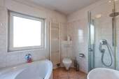 Badezimmer mit Badewanne und Dusche - 