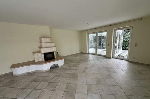 Wohnbereich mit Kachelofen, Zugang zum Wintergarten - 