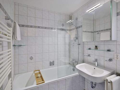 Hell gefliestes Bad mit Duschwanne und Waschmaschinenanschluss - 