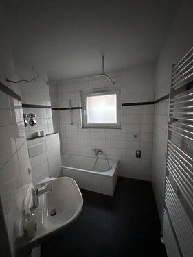 Tageslichtbad mit weißen Wandfliesen, grauen Bodenfliesen und weißer Badewanne, Waschbecken und WC. - 4 Zimmer Etagenwohnung zur Miete in Bad Homburg vor der Höhe