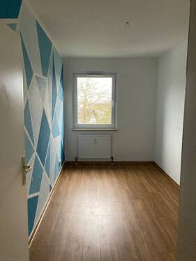 Kinderzimmer mit weiß blauen Wänden und einem Design-Vinylboden in Holzoptik mit Fenster. - Etagenwohnung mit 82,60 m&sup2; in Bad Homburg vor der Höhe zur Miete
