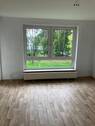 Wohnzimmer mit großem Fenster und Zugang zum Balkon.jpg - Helle 3-Zimmer Erdgeschosswohnung mit neuen Bodenbelägen und Loggia zu vermieten