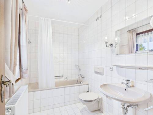 Helles Tageslichtbad mit Badewanne, WC und Waschtisch, gepflegt im klassischen Stil - 