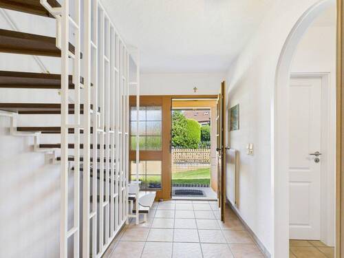 Heller Eingangsbereich mit Holztreppe und direktem Zugang in den liebevoll angelegten Garten - 5 Zimmer Einfamilienhaus in Egenhofen