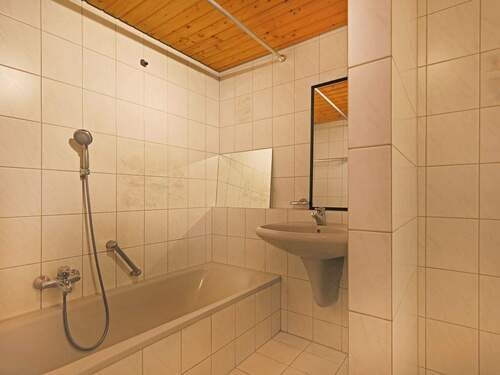 Praktisch aufgeteiltes Badezimmer mit Badewanne und Nische für die Waschmaschine - 