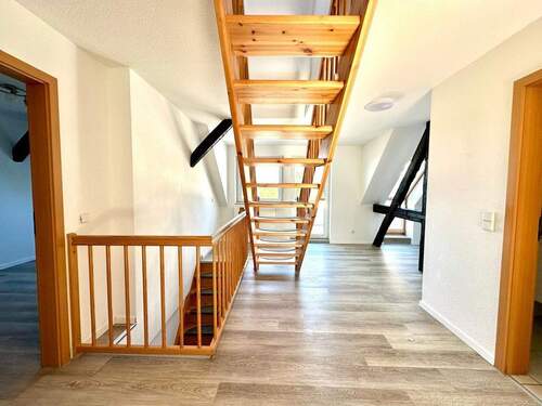 Offen gestalteter Wohnraum mit Treppe ins Obergeschoss - 