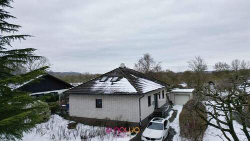 Außenansicht: der Blick auf den Bungalow, die Einfahrt und die Garage - Mit ca. 120 m² Ausbaureserve: Bungalow mit Potenzial für bis zu zwei Familien!