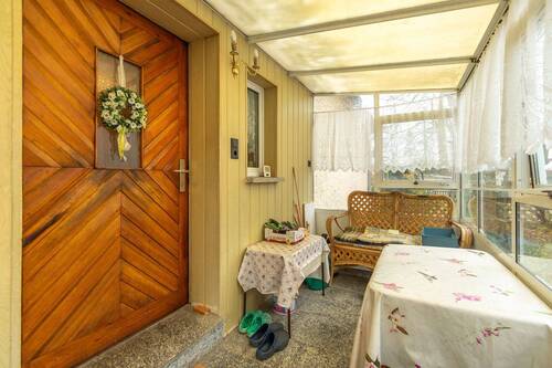 Hauseingangstür über Veranda mit Sitzecke - 