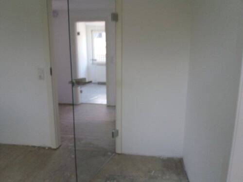 Blick vom Wohnzimmer durch zwei Glastüren in die Küche - 