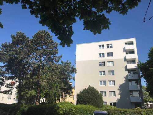Gebäudeansicht mit Balkonen umgeben von Bäumen und Büschen - Frisch für Sie saniert - 700,00&nbsp;EUR Kaltmiete, ca.&nbsp; 61,40&nbsp;m&sup2;&nbsp;Wohnfl&auml;che