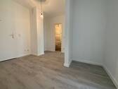 Blick von Wohnungseingangstür in Diele mit grauem PVC-Boden und weißen Wänden von dort sieht man die Zimmereingänge mit weißen Türrahmen - 2 Zimmer Etagenwohnung in Meerbusch