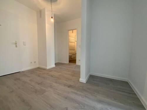 Blick von Wohnungseingangstür in Diele mit grauem PVC-Boden und weißen Wänden von dort sieht man die Zimmereingänge mit weißen Türrahmen - 2 Zimmer Etagenwohnung in Meerbusch